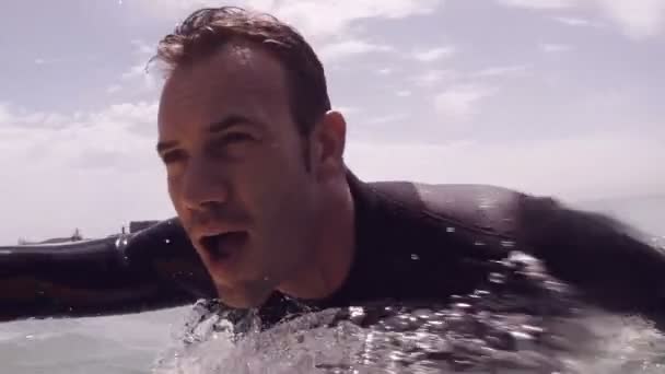 Hombre guapo surfeando en el mar — Vídeos de Stock