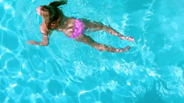 Hübsche Frau schwimmt im Pool — Stockvideo