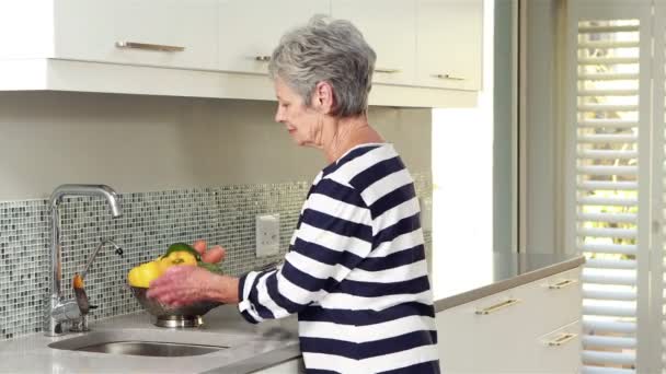 Mujer mayor lavando algunas verduras — Vídeos de Stock