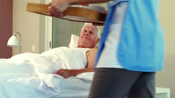 Krankenschwester schenkt Tablett mit Frühstück an Seniorin — Stockvideo