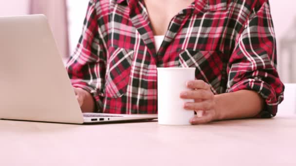 Kvinna som använder laptop medan du dricker kaffe — Stockvideo