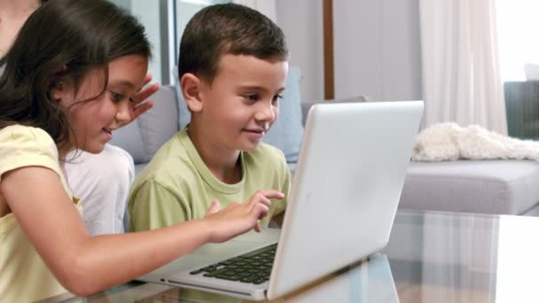 Schattig broers en zussen met laptop in de woonkamer — Stockvideo