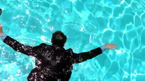Businessman floating in the pool — Stock Video