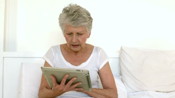 Старшая женщина с помощью планшета — стоковое видео