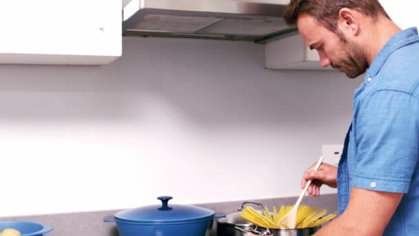 Stilig man matlagning pasta i köket — Stockvideo