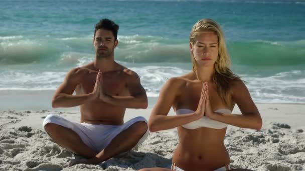 Coppia facendo yoga accanto all'acqua — Video Stock