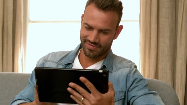 Homme utilisant une tablette sur le canapé — Video