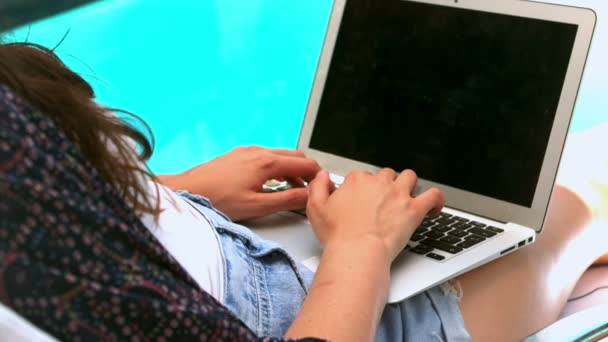 Жінка використовує ноутбук біля басейну — стокове відео