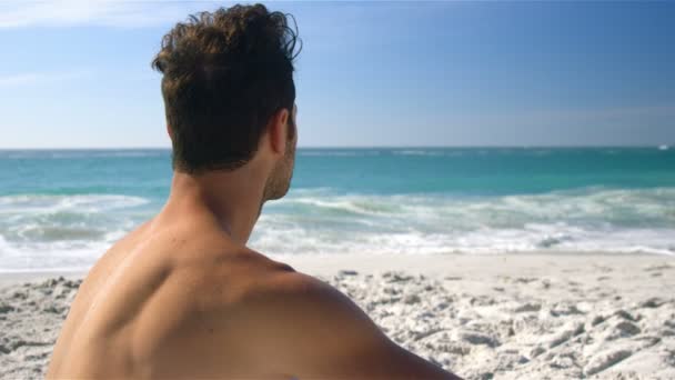 Man die zich voordeed op het strand — Stockvideo