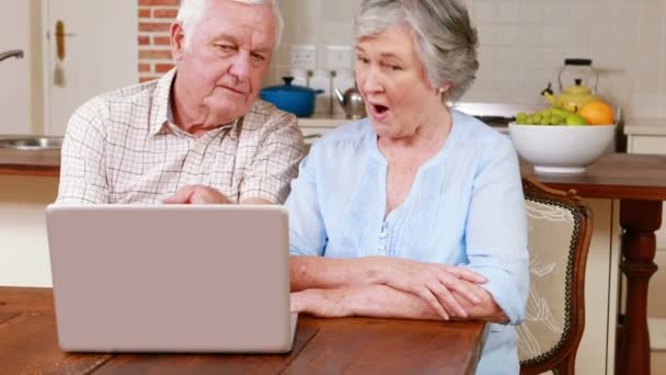 Старша пара використовує ноутбук разом — стокове відео