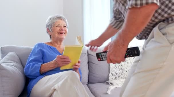 Mignon vieux couple lecture ou regarder la télévision — Video