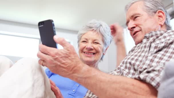 Linda pareja de ancianos usando teléfono inteligente — Vídeo de stock