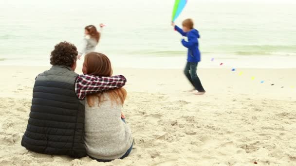 Barn som leker med kite medan föräldrar sitter — Stockvideo