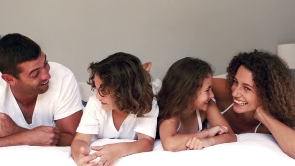 Leuke familie lachen op hun bed — Stockvideo