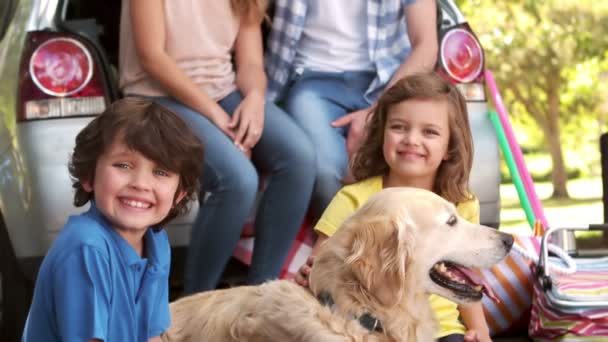 Família com cão sentado no porta-malas do carro — Vídeo de Stock