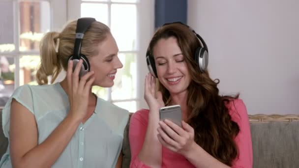 Друзья слушают музыку с наушниками — стоковое видео