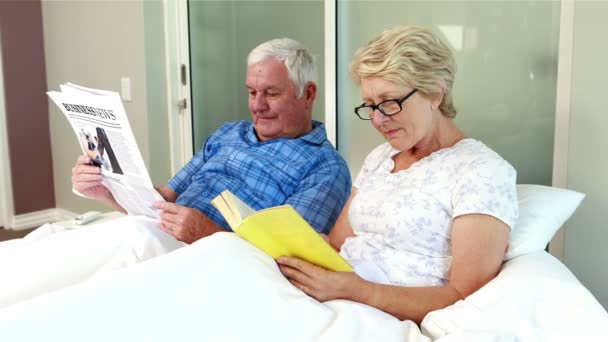 Pareja mayor leyendo libro y periódico — Vídeos de Stock