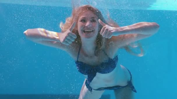 Mujer bonita mostrando un pulgar hacia arriba bajo el agua — Vídeos de Stock