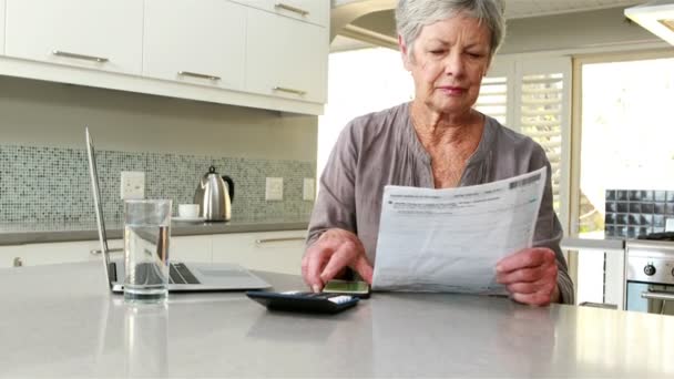 Happy woman using a calculator — Stock Video