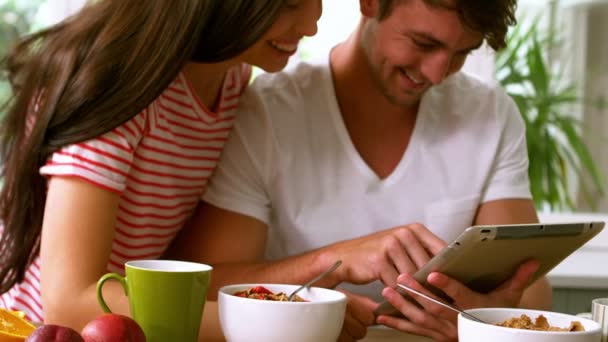 Glückliches Paar nutzt Tablet und frühstückt — Stockvideo