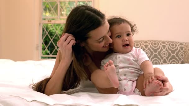 Мать с симпатичным ребенком, сидящим на кровати — стоковое видео