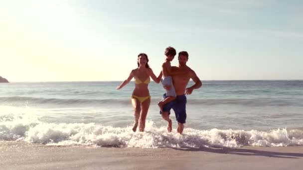 Familia feliz corriendo en el agua — Vídeo de stock