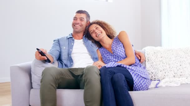 Linda pareja joven viendo la televisión — Vídeo de stock