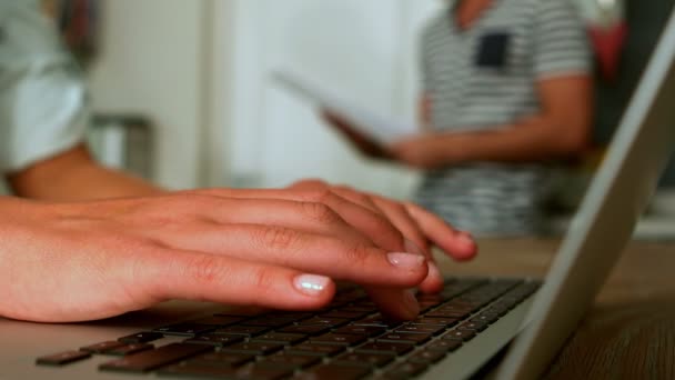 Γυναίκα χρησιμοποιώντας φορητό υπολογιστή ενώ άτομο διαβάζει εφημερίδα — Αρχείο Βίντεο