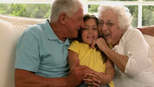 Abuelos besando nieta en sofá — Vídeos de Stock