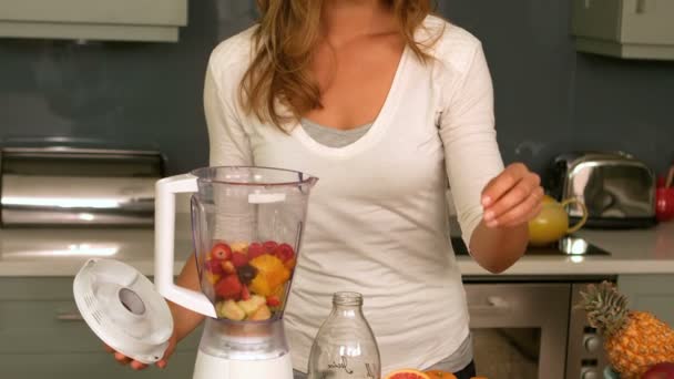 Pretty woman preparing a smoothie — Stock Video