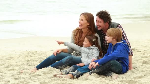 Familia sentada en la playa — Vídeos de Stock