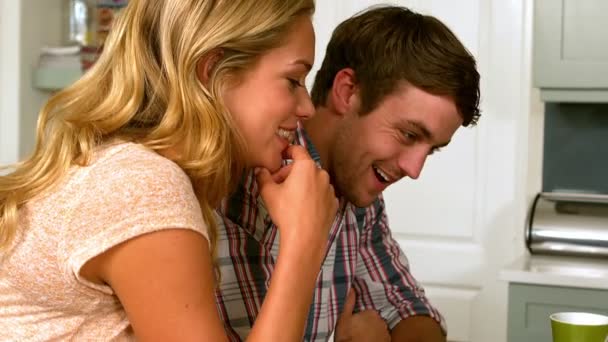 Pareja feliz usando portátil en la cocina — Vídeo de stock