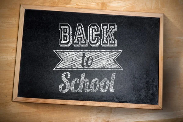 Back to school against chalkboard on desk — Stock Photo, Image