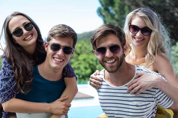 Männer geben Frauen Huckepack zurück — Stockfoto