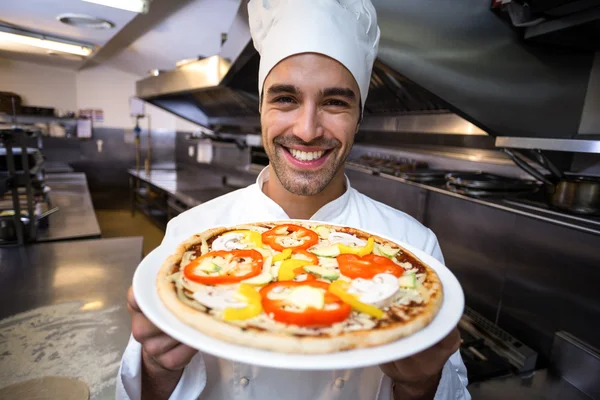 Chef bonito apresentando pizza — Fotografia de Stock