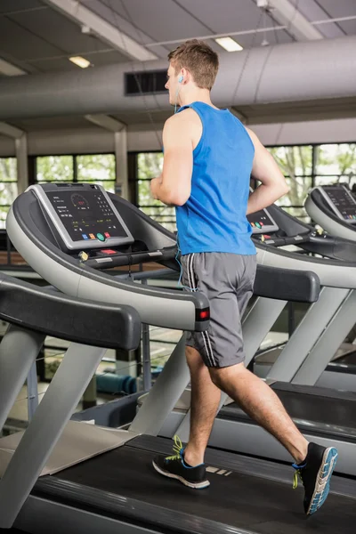 Hombre en la cinta de correr escuchando música — Foto de Stock