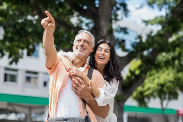 Man pointing while woman hugging him — Stock Photo, Image