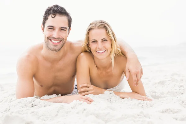 Happy couple lying on the beach — Stock Photo, Image