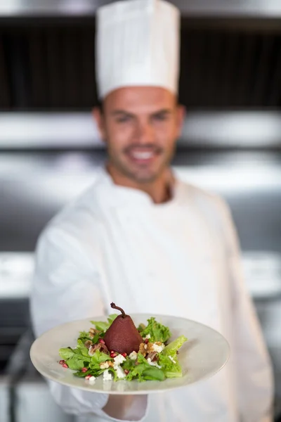 Chef-kok bedrijf plaat in keuken — Stockfoto