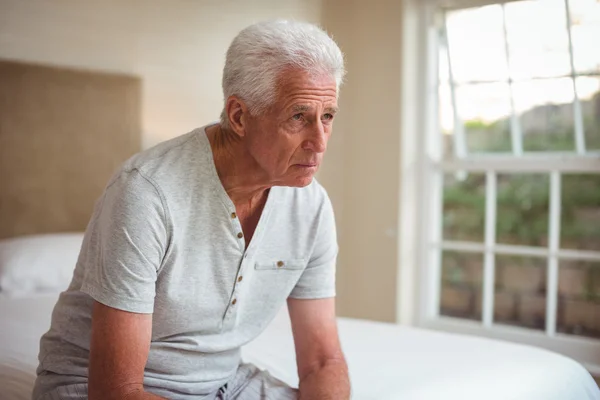 Doordachte senior man zittend op bed — Stockfoto