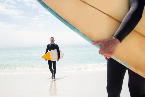 Homem caminhando com prancha na praia — Fotografia de Stock