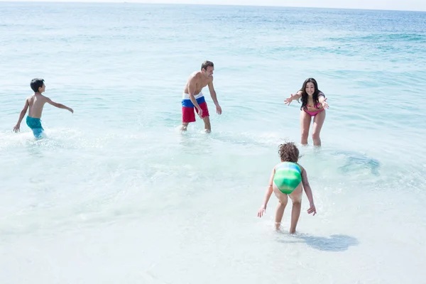 Família feliz brincando na praia — Fotografia de Stock
