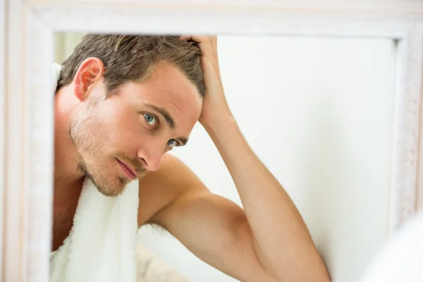 Mann überprüft seine Haare im Spiegel — Stockfoto