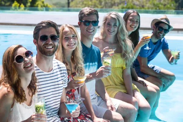 Friends sitting in swimming pool — Stock Photo, Image