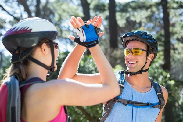 Couple wearing helmets giving high five — Stock Photo, Image