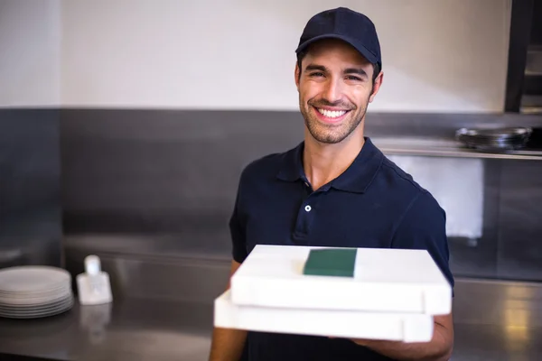 Доставщик пиццы показывает коробку — стоковое фото