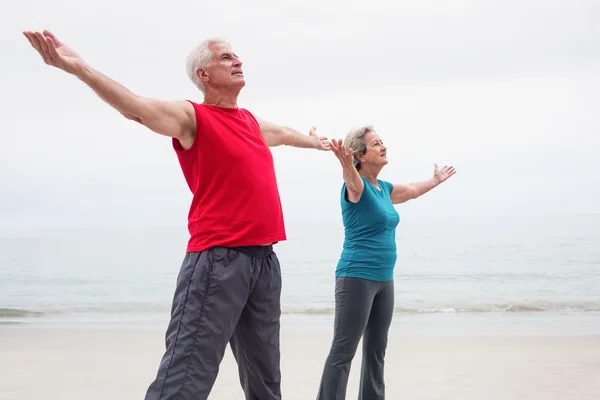 Senior paar met uitgestrekte armen — Stockfoto