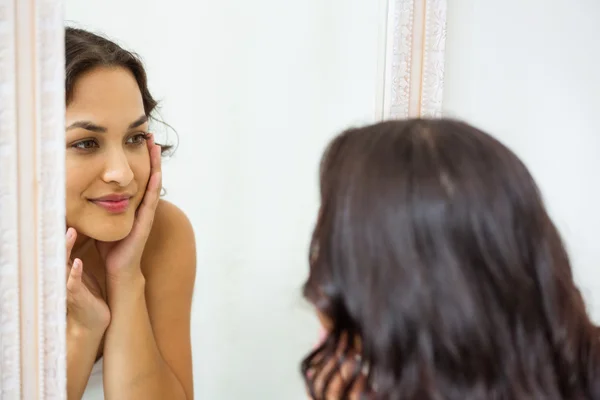 Frau blickt in Spiegel des Badezimmers — Stockfoto