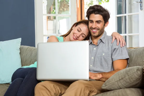 Feliz jovem casal usando laptop — Fotografia de Stock