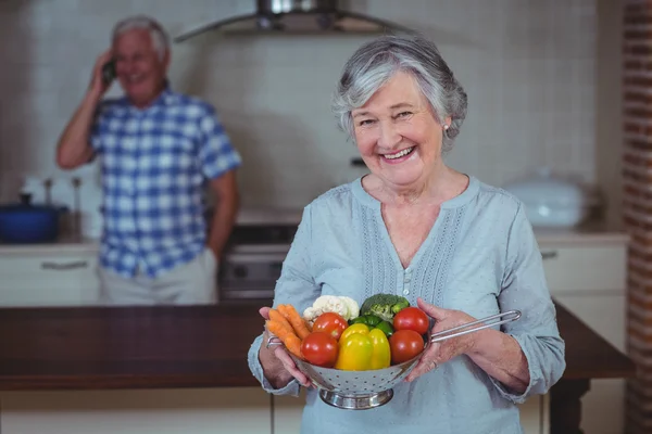 Senior woman holding colander — Stock Photo, Image